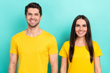 Photo portrait of two young people wear yellow t-shirt logo brunette hair woman cheerful smile with man isolated on aquamarine color background