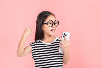 Little girl play phone mobile. Isolated on pink background