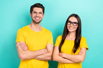 Photo of two confident brother with sister wear yellow t-shirts brand stylish eyeglasses crossed hands promo banner isolated on cyan color background - obrazy, fototapety, plakaty
