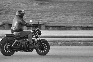 Obraz na płótnie Canvas 14.05.23 Montevideo, Uruguay, motorcycle on the road driving fast. having fun on the empty road on a motorcycle trip. Fast motion blur effect, white and black