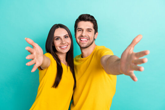 Photo of cheerful funny married couple wear yellow t-shirts hugging open arms isolated teal color background