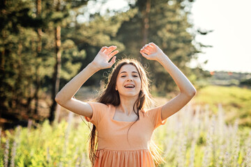 Naklejka na ściany i meble Positive emotions like happiness, excitement, joy, hope, and inspiration is vital for happy and healthy life. Outdoor portrait of happy smiling young woman in nature background