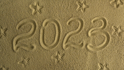 Signpost 2023 written in sand. There is space for text.