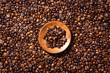 Obraz premium Palone ziarna kawy i drewnianym podstawkiem z mieloną kawą