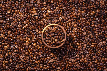 Palone ziarna kawy wypełniające tło z miseczką pełną ziaren kawy