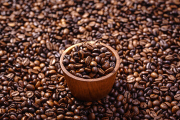 Palone ziarna kawy wypełniające tło z miseczką pełną ziaren kawy