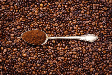 Palone ziarna kawy  z łyżką wypełnioną mieloną kawą