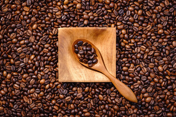 Palone ziarna kawy z drewnianym podstawkiem wypełnionym kawą - obrazy, fototapety, plakaty