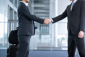  Image of a successful business transaction or business meeting of hands of two men in suits...