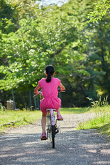 夏の公園で元気で自転車を乗って遊んでいる小学生の女の子の様子