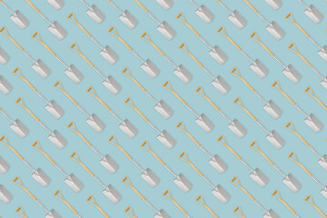 Seamless pattern with gardening tool and garden equipment, spade with wooden handle, isolated top view on light blue background. Wrapper template for greenhouse or flower shop.
