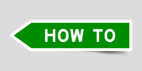 Green color arrow shape sticker label with word how to on gray background