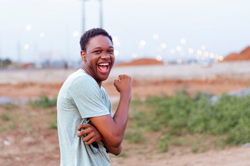 overexcited young black man isolated over a blurry city background