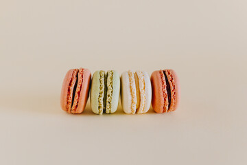 Tasty french macarons on a peach pastel background.