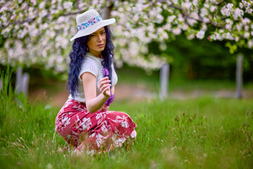 portrait of a beautiful brunette woman in a blossoming apple orchard