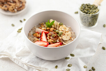 Portion of healthy oatmeal porridge with strawberries and banana