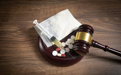 Judge gavel with a syringe, drugs, packet of heroin.