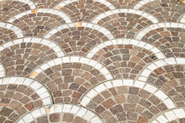 Half round bricks laid out on the sidewalk.
