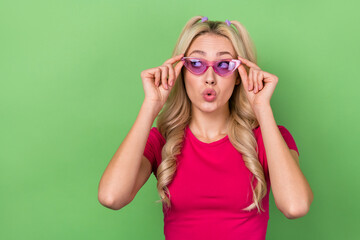 Photo of impressed funky lady dressed pink t-shirt arms glasses looking empty space isolated green color background
