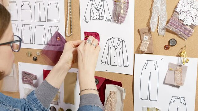 Woman fashion designer with sketches in the studio. Seamstress at work.	