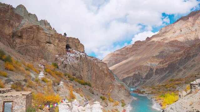 4K shot of ancient Phugtal Monastery made in a natural cave near Purne village in Zanskar, Ladakh India. Old Buddhist monastery with flowing blue Tsarap river. Nature Landscape. Travel India concept.