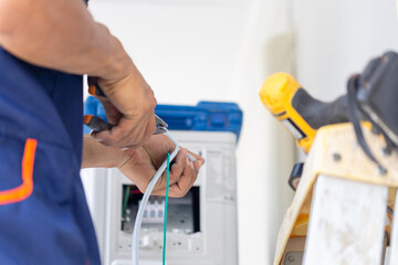 Technician man installing air conditioning in a client house, Young repairman fixing air conditioner unit, Maintenance and repairing concepts