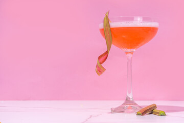 Rhubarb summer cold plum daiquiri or martini cocktail, liquor with pink Rhubarb,crushed ice and bar utensils on high-colored background