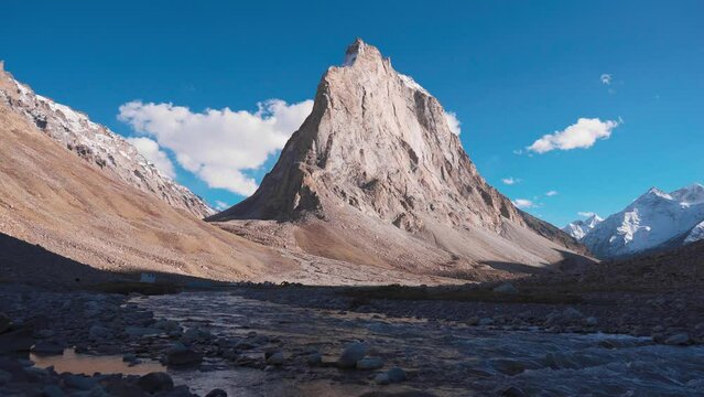 4K shot of mighty Gonbo Rangjon mountain peak and flowing Kargyak Chu river at Zanskar, Ladakh, India. Remote Himalayan mountain range. Zanskar during Summer day. Travel and holiday concept.