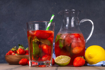 Homemade Strawberry lemonade in jar and glass, with many crushed ice, sliced berries and mint leaves, Frozen strawberry sangria, Iced Tea or mojito drink