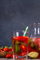 Homemade Strawberry lemonade in jar and glass, with many crushed ice, sliced berries and mint leaves, Frozen strawberry sangria, Iced Tea or mojito drink