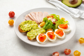 Healthy breakfast with eggs salmon and avocado toasts