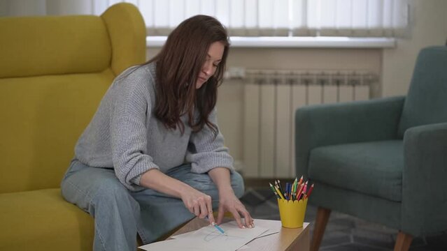 a woman draws a house with a red pencil. woman painting.. High quality FullHD video recording