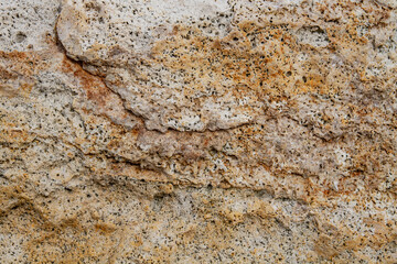 The texture of the stone is notched and mottled. holes notches grooves on the stone.