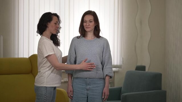 two women. A woman practices Reiki by directing energy through her palms. women practice qigong. High quality Full HD video recording