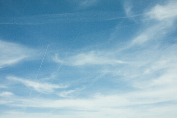 White clouds on blue sky  in retro style with grain