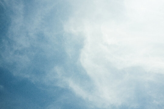 White clouds on blue sky  in retro style with grain