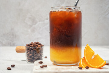 Bumble coffee mix with orange juice and cold brew coffee with ice. Summer trendy refreshing coffee drink.