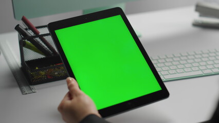 Manager using mockup tablet with green screen closeup. Hands hold chroma key