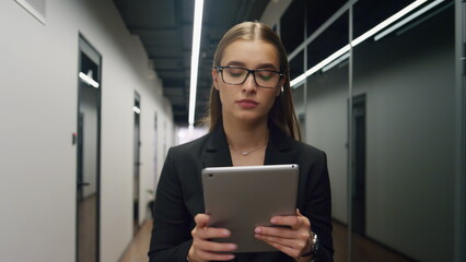 Financial manager using tablet computer in office. Focused employee surfing web