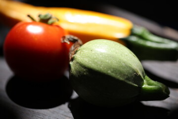 three different vegetables on a wooden plate isolated