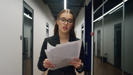 Stressed manager throwing papers in glass office. Upset woman walking hallway