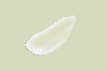 The flowing cream on a green background. Smudged flowing smear of cosmetic cream.