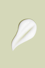 The flowing cream on a green background. Smudged flowing smear of cosmetic cream.