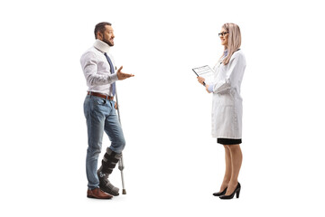 Fototapeta premium Injured man with an orthopedic boot and cervical collar talking to a female doctor