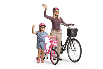 Little girl with her mother waving and standing with a bicycle