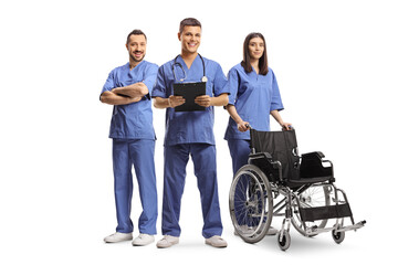 Obraz na płótnie Canvas Medical workers in blue uniforms standing with a wheelchair