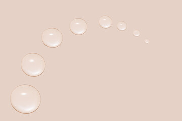 Drops of transparent gel or water in the shape of a semi-circle, with decreasing size. On a beige background.