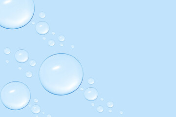Drops of transparent gel or water in different sizes. On a blue background.