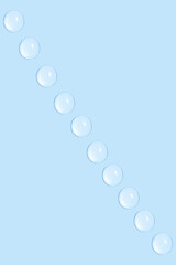 Drops of transparent gel or water in a row. On a blue background.