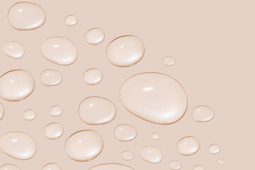 Drops of transparent gel or water in different sizes. On a beige background.